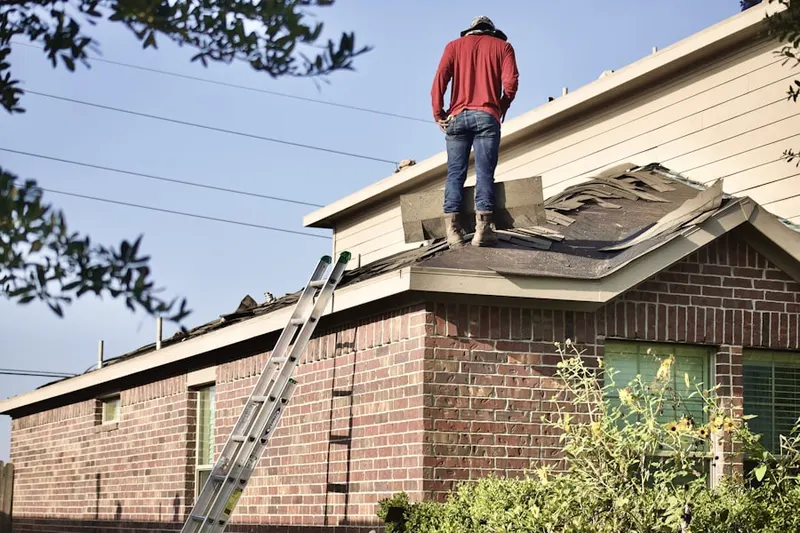 Professional roofer working on a residential roof in Greenacres Place